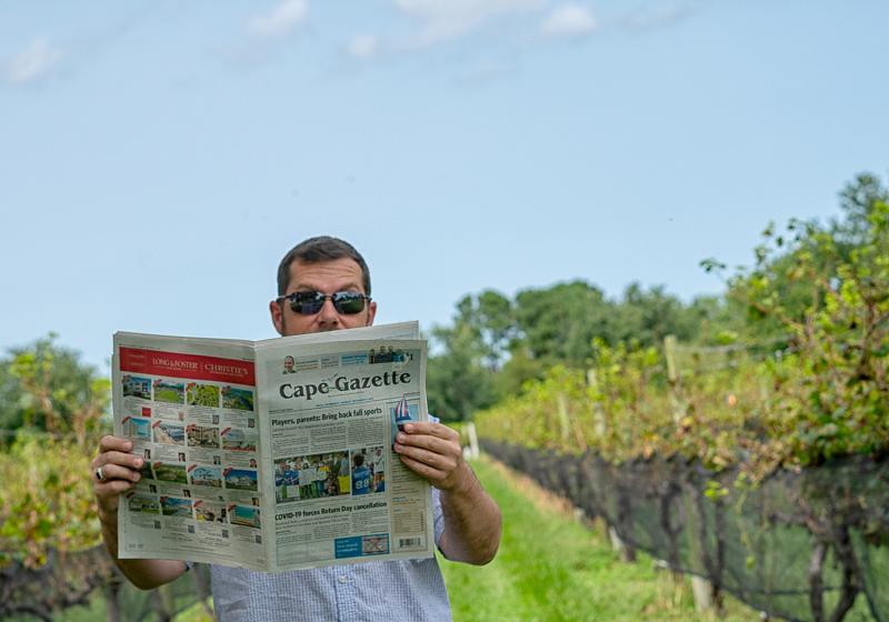Cape Gazette Coordinator Edwin Krumm takes advantage of the wonderful weather to check the print job of the newspaper. Like many of his coworkers, he enjoys walking around Nassau Valley Vineyards, which is across from the Cape Gazette office.