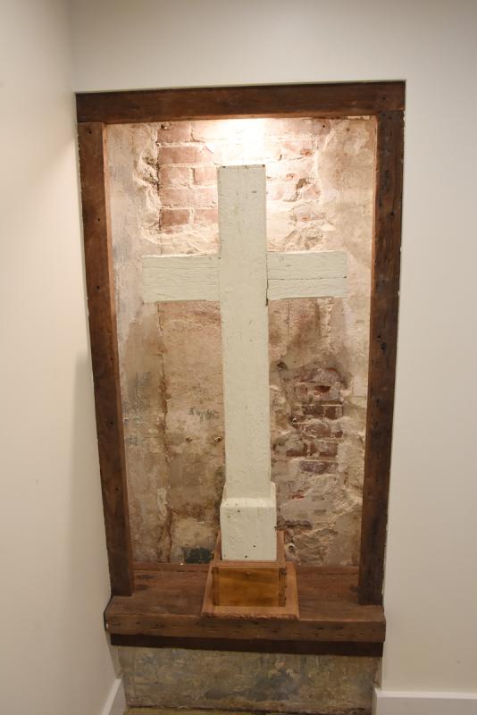 The cedar cross that sat atop the steeple since 1870 is now preserved in the church basement.
