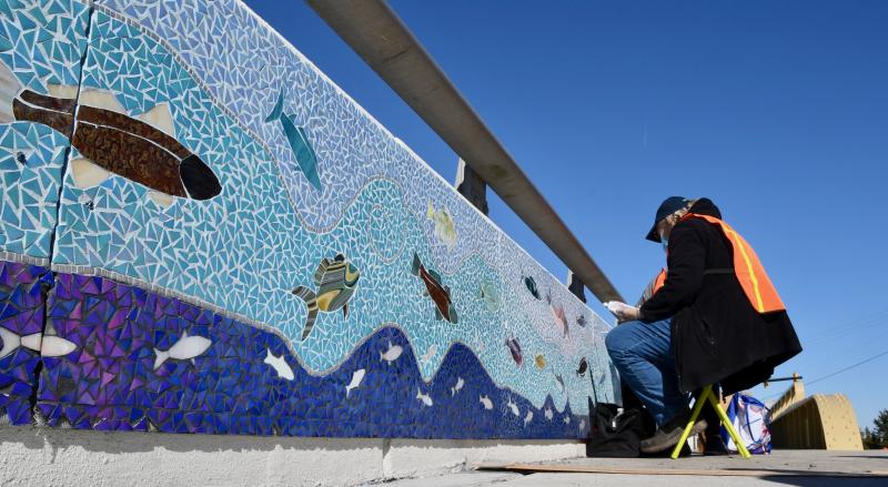 Mosaic artist Lorelei Meanor sees her idea come to fruition as mosaic mural panels are placed on the Lewes drawbridge. Volunteers did the artwork, working more than 1,000 hours.