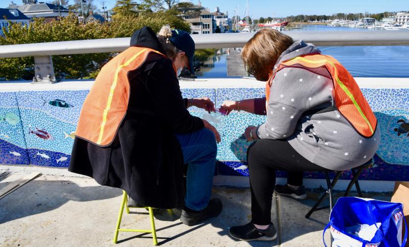 Artist Lorelei Meanor, left, and volunteer Terry Lake work as a team.