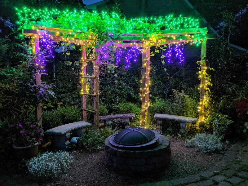 Lighted grapevines beautify a fireside arbor at Mill Pond Garden. SUBMITTED PHOTOS