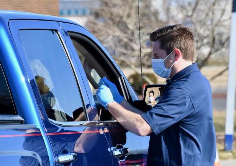 Division of Pubic Health’s Richard Pescatore vaccinates a drive-thru patient during a three-day clinic in Dover. RON MACARTHUR PHOTOS