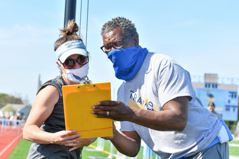 Coaches Jamie Loucks and Jay Maull go over long jump entries.