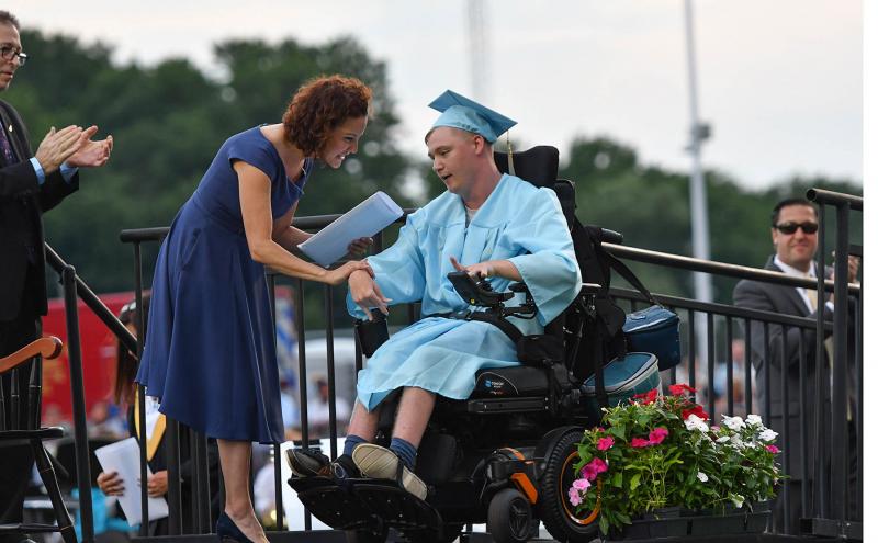 Luke Williams receives his diploma from board President Dr. Alison Myers.