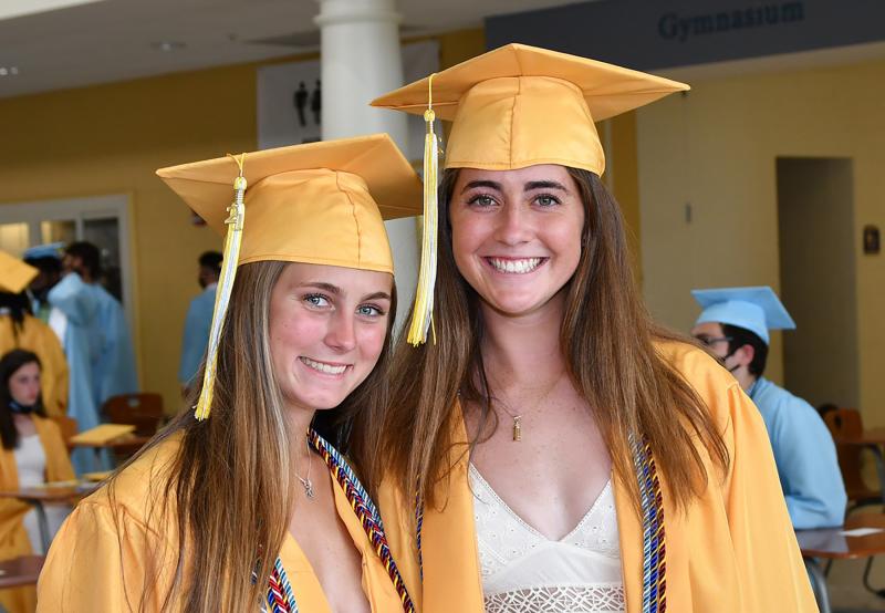 Friends and lacrosse teammates Haley Craig, left, and Emily Monigle smile as they await the processional.