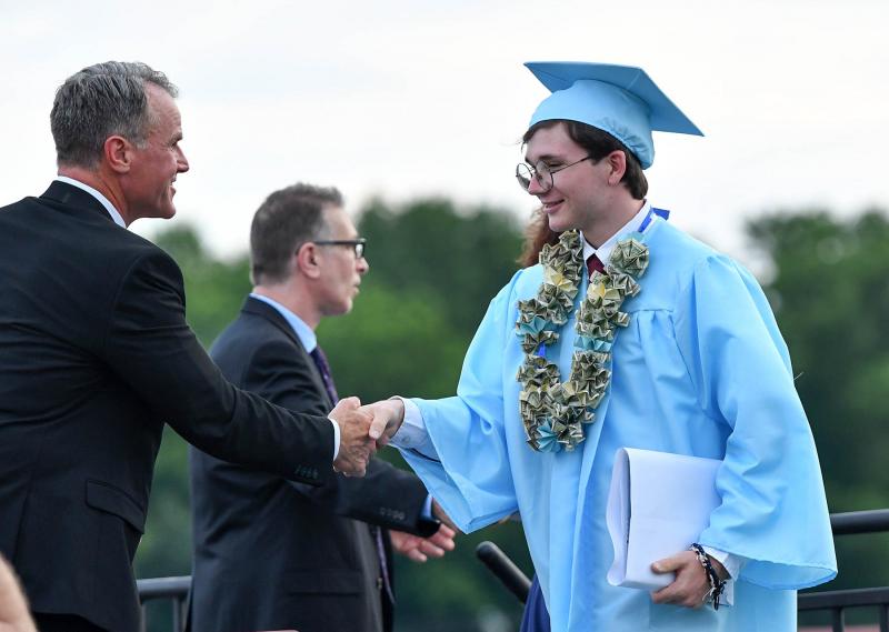 Nathan Davis receives congratulations from Superintendent Bob Fulton.