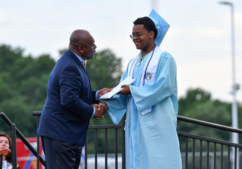 Dion Dante Johnson Jr. receives his diploma from board member Bill Collick.