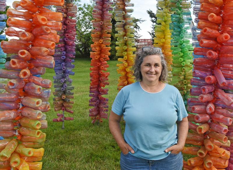 Artist Kate Dodd stands among the stalks.