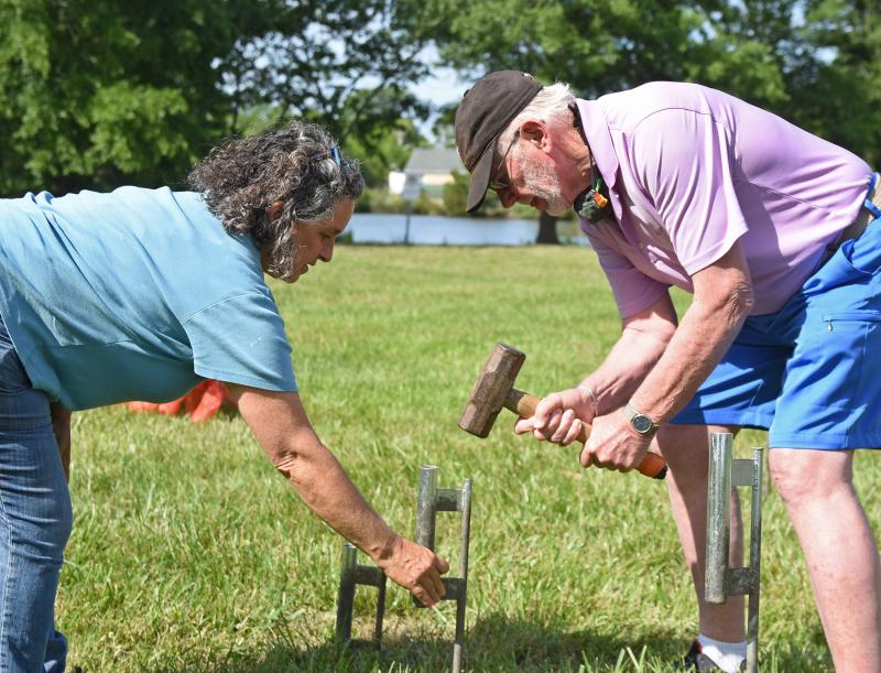 Artist Kate Dodd and Peninsula Gallery owner Tony Boyd-Heron hammer a stake into the ground.
