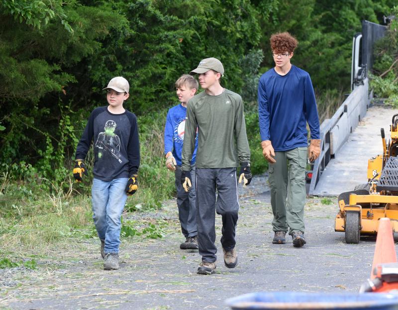 A group of scouts heads back for more work after loading a trailer with branches and debris.