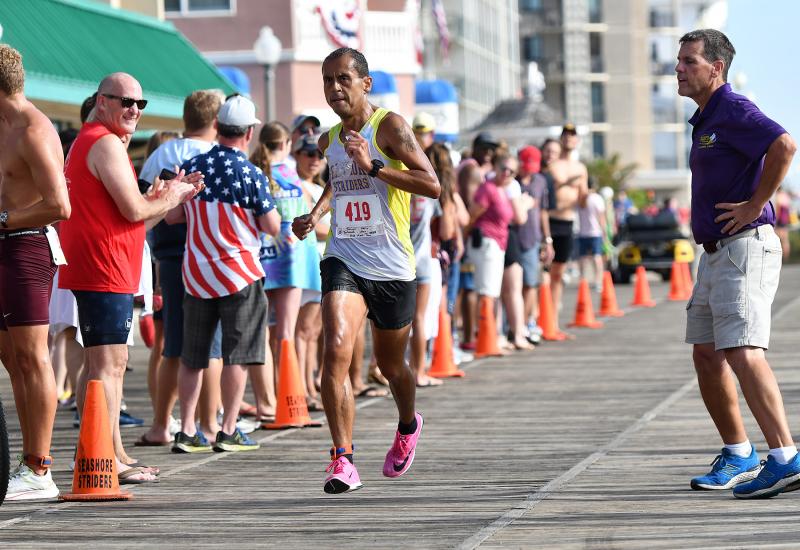 Race director Tim Bamforth, right, announces Martin Rodriguez, who ran the team leg with swimming partner Adam Bartoshesky to a second-place time of 29:29.