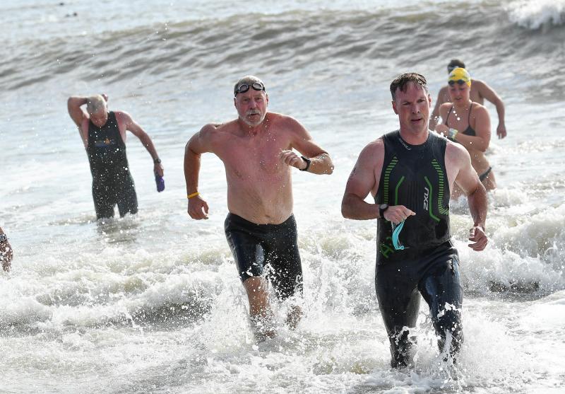 Swimmers run from the Atlantic.