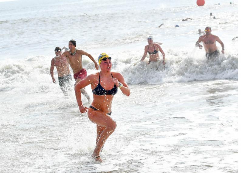 Swimmers dash to the beach out of the Atlantic waves.