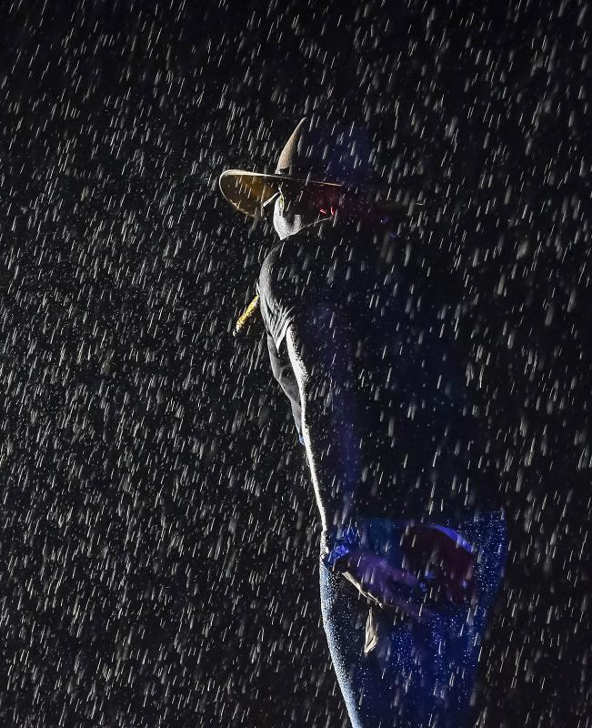Jimmie Allen’s hat is silhouetted in the rain.