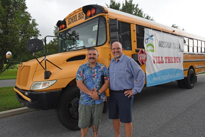 Standing next to the bus that will be headed to the Dominican Republic are New Covenant Presbyterian Church worship leader Shawn Rineholt and Senior Pastor Robert Dekker. NICK ROTH PHOTO