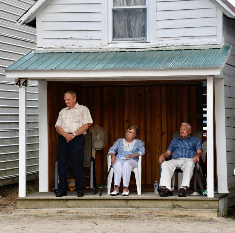 Like a scene from yesteryear, camp-goers sit on their open porch to listen to one of the nightly services.