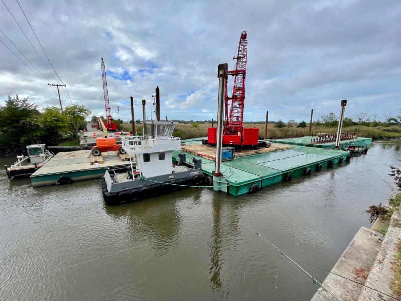 Crane-bedecked barges, spudded into the river bottom of the Broadkill, lie ready to begin the heavy lifting scheduled to start in October. DENNIS FORNEY PHOTO
