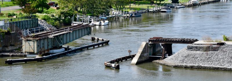 Work to remove and relocate the railroad swing bridge, shown at left, is expected to begin in November. The large embankment at right will removed as part of the project. RON MACARTHUR PHOTOS