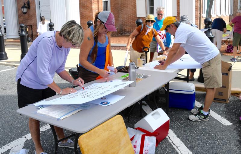 Residents make signs at the site of the protest in front of the Sussex County administration offices on The Circle in Georgetown.
