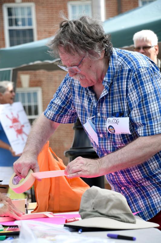 Keith Steck, vice president of Delaware Coalition for Open Government, helps residents make signs during the Sept. 21 protest.