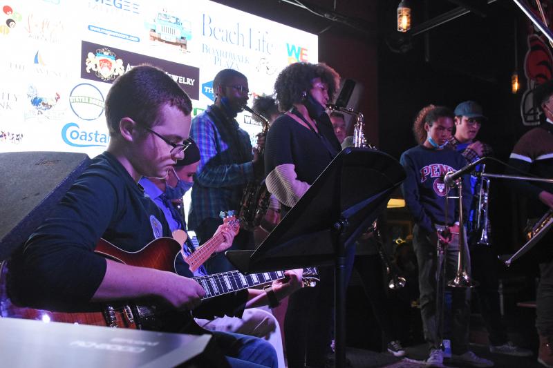 Ryan Mountz plays guitar with a group of Dover performers.