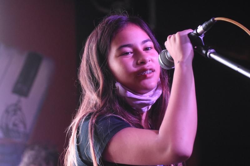 Grace Thomas announces the song she’s about to play with her twin brother Jack and older brother Dylan.