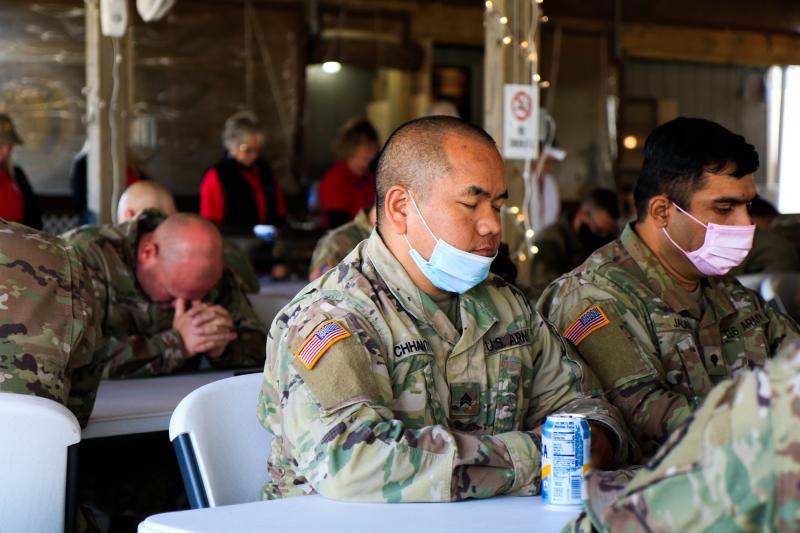 Army Reservists observe a moment of silence before getting their food. KAIT MOORE PHOTO