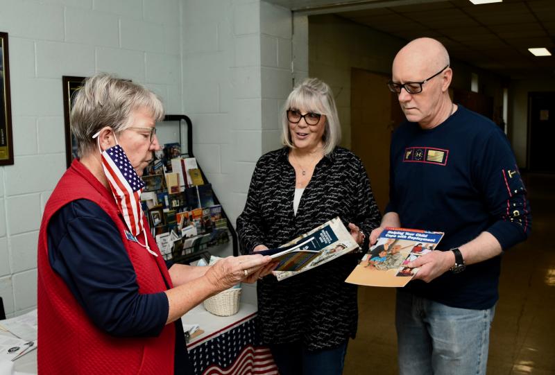 Murt Foss, of American Legion Unit 17, explains some of the literature to volunteers Colleen and Ed Sinkson that will be given to soldiers to add them and their families during their one-year deployment.