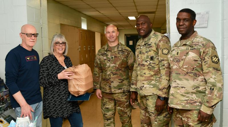 Volunteers Ed and Colleen Sinkson give lunches to members of the 946th Transportation Company (l-r) Nicholas Scheuring, Thaddeus Alexander and William Reuben.