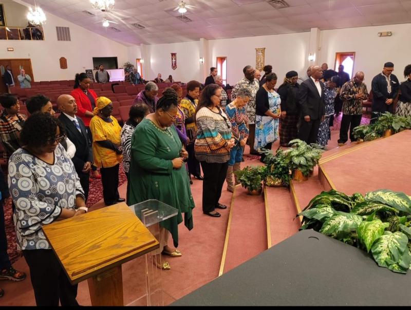 In the Trinity Faith Christian Center sanctuary, members bow their heads in prayer.