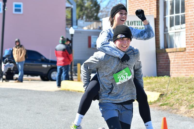 Brian Sponaugle carries Mia Nuebling across the finish line.
