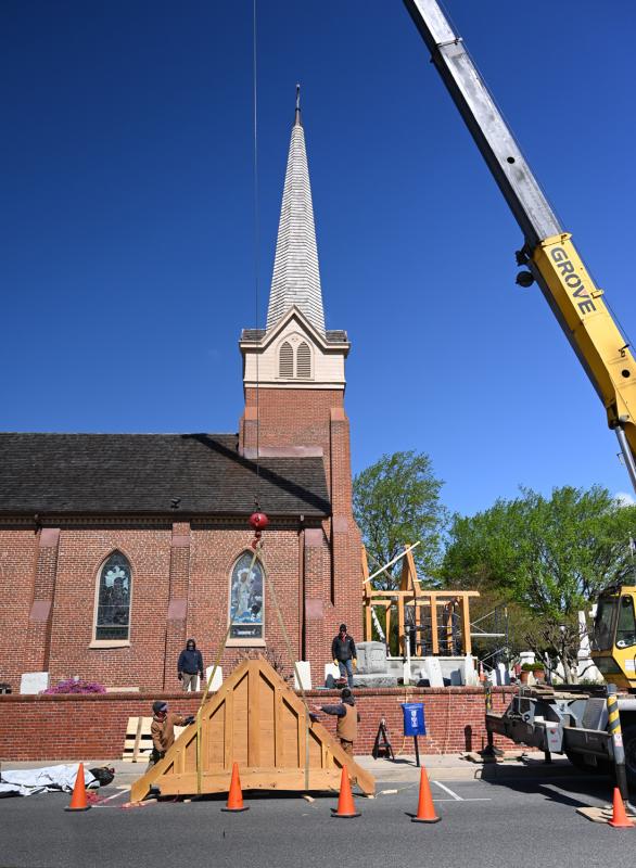 Crews secure a piece of the portico before lifting it via crane.