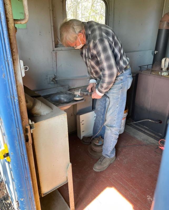 Volunteer Jerry Virden sands down a section of sink inside the caboose.