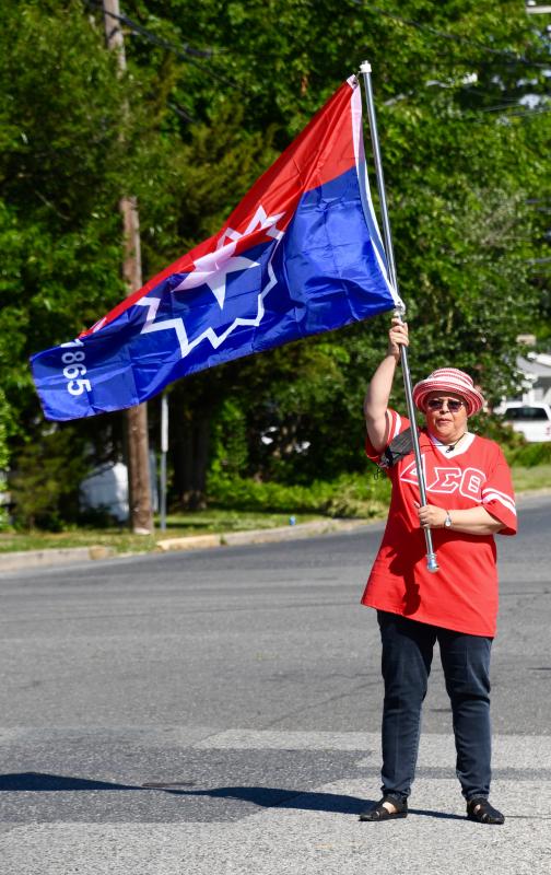 Paula Roberts waves a Juneteenth flag to get everyone lined up for a parade to kick off the celebration in Georgetown.