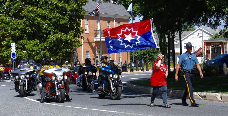 Paula Roberts, with Juneteenth flag, and Delaware State Police Trooper Patrick Johnson lead the parade through downtown Georgetown to the Richard Allen School. RON MACARTHUR PHOTOS