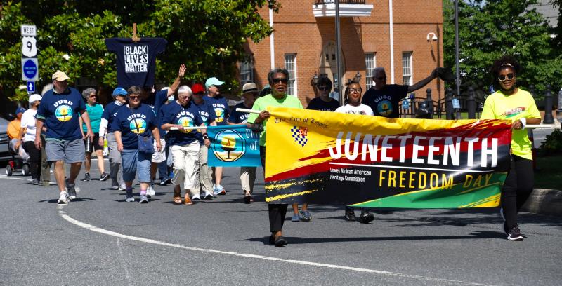 Members of the Lewes Juneteenth committee walk with a banner for the upcoming Lewes celebration Saturday, June 25.