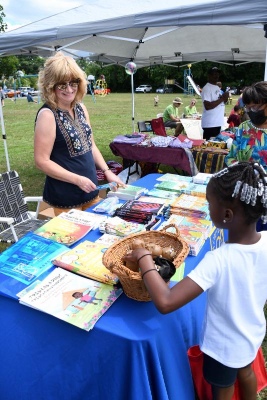 Barbara Johnson, a member of the Delaware Readiness Team, hands out free books as part of a Department of Education summer literacy program.