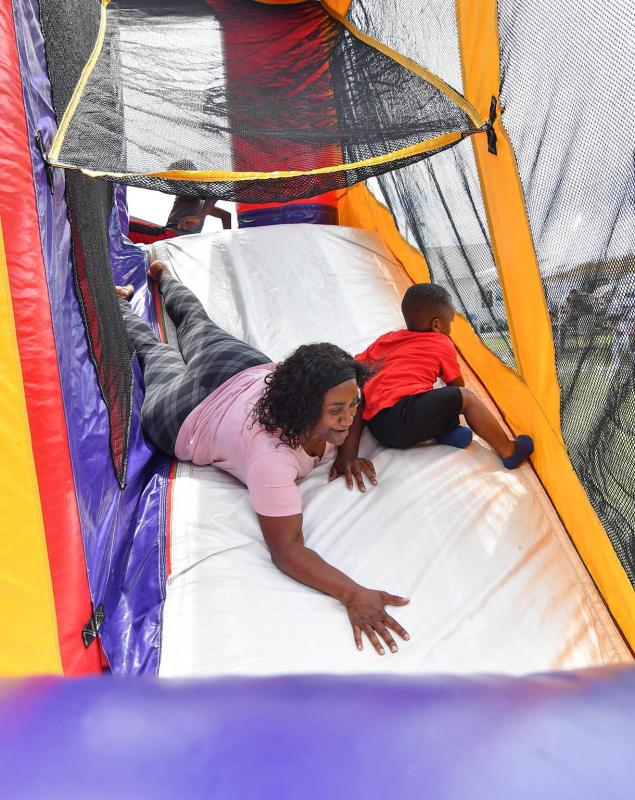 Grandmom Stacy White tries her hand at the bouncy house slide with her grandson Eli.