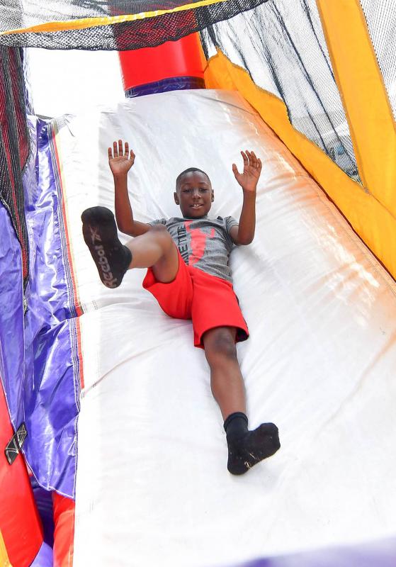 Aiden White, 8, takes a jump on the bouncy house slide.