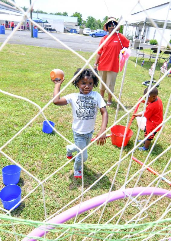 Damani White, 4, throws a ball through the hoop for a prize.