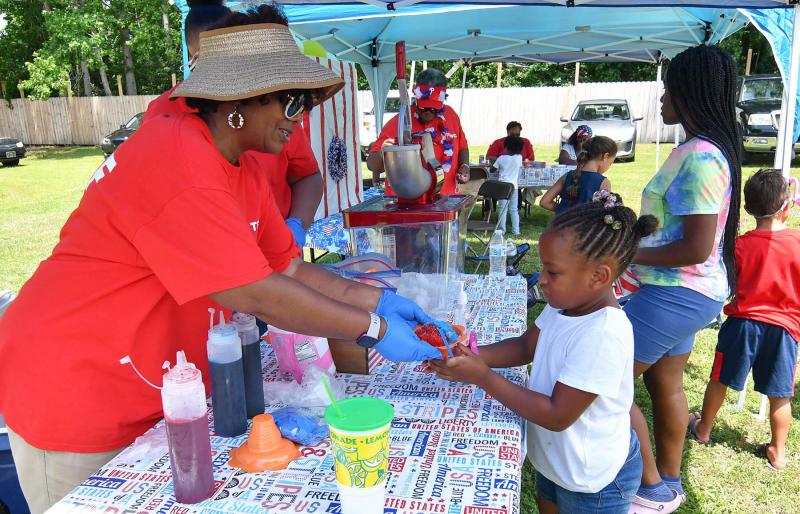 Jada Mobley, 6, gets a tasty ice cone from Trina Brown-Hicks during the kids’ games during the Fourth of July celebration at Trinity Faith Christian Center in Lewes. DAN COOK PHOTOS