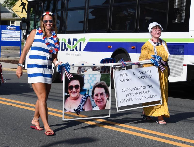 Ashley Hoenen Tanis, Phyllis’ granddaughter, left, and Kathy Hoenen-Enevold, Phyllis’ daughter, carry a banner in memory of the founders of the Doo-Dah Parade, Phyllis Hoenen and Carolyn Shockley.