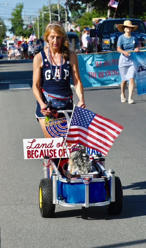 Erika Caldwell of Lewes pushes her dog, Jesse James, in his own decorated wagon.