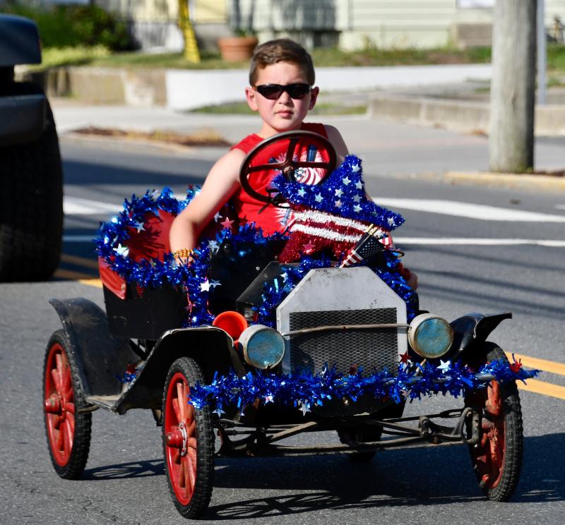 Jackson Pfirman may not have his license, but he has no trouble driving an antique mini-car in the parade.