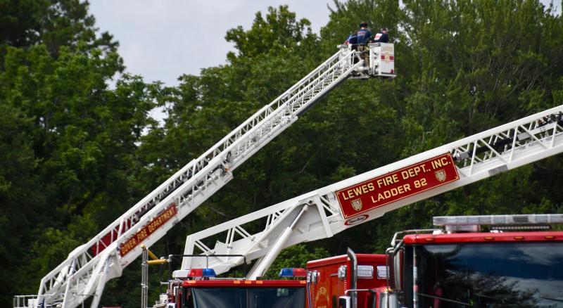 Dover Fire Department firefighters guide a ladder back to the top of an aerial truck.