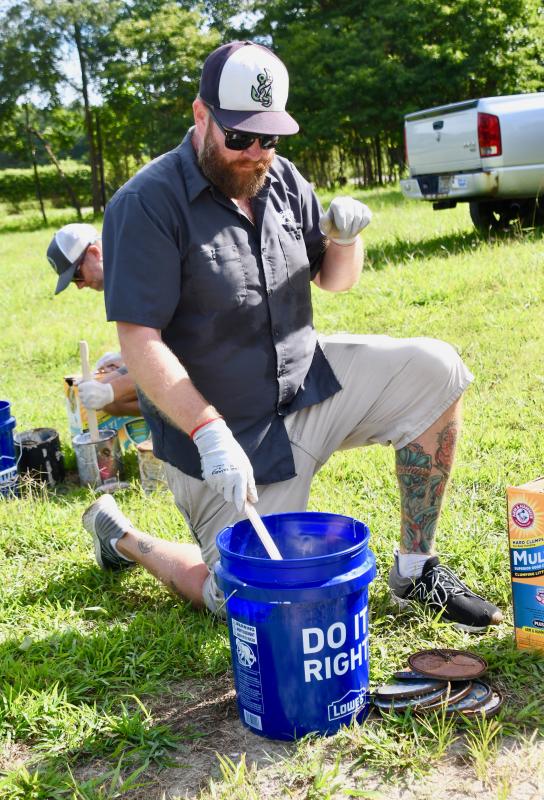 Jon March mixes a concoction of old paint and kitty litter in a process to stabilize the paint for disposal.