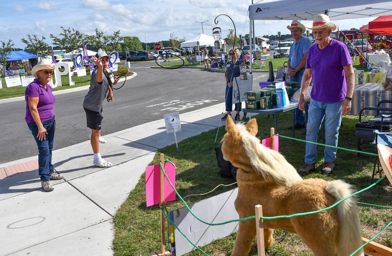 Matthew Westcott tosses a ring around the horse’s neck at the Grace Church booth for a cool prize.