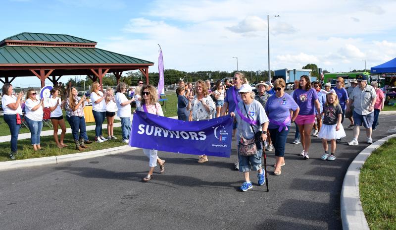 The people cheer as the cancer survivors walk the lead lap of Relay for Life.