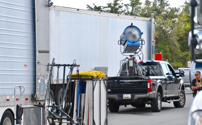 Tractor-trailers filled with filming equipment are being unloaded near Herring Point.