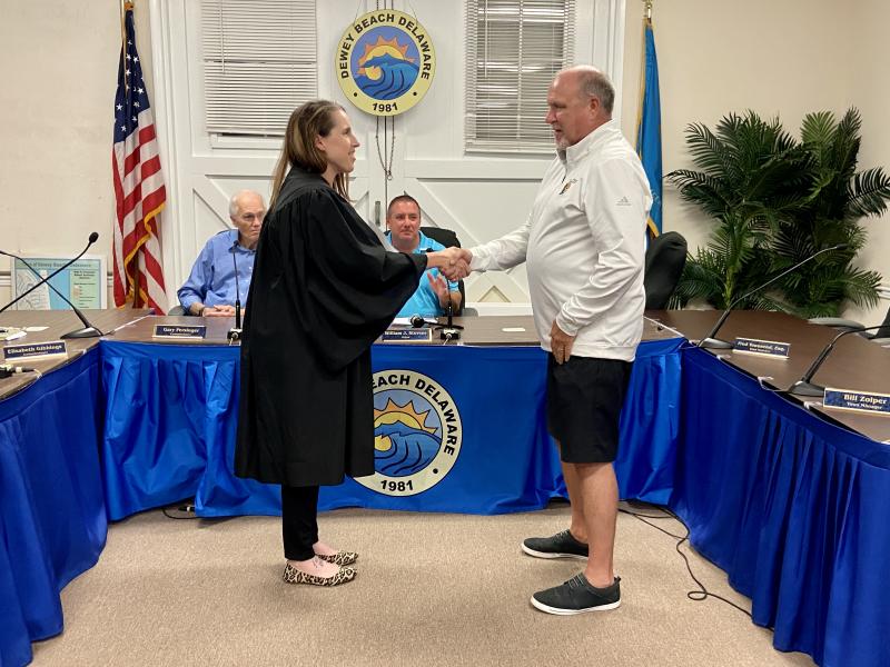 Dewey Beach Commissioner Paul Bauer is sworn into his fourth one-year term as secretary by Alderman Kelly Pettyjohn.
